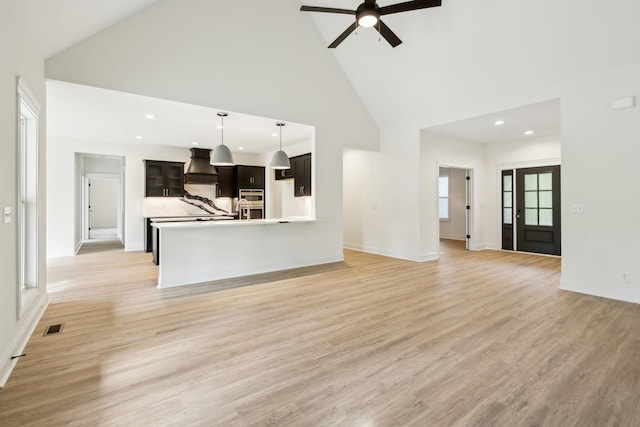 1049 Gholson Rd, Clarksville, TN 37043 - unfurnished living room featuring visible vents, a ceiling fan, baseboards, light wood-style flooring, and high vaulted ceiling