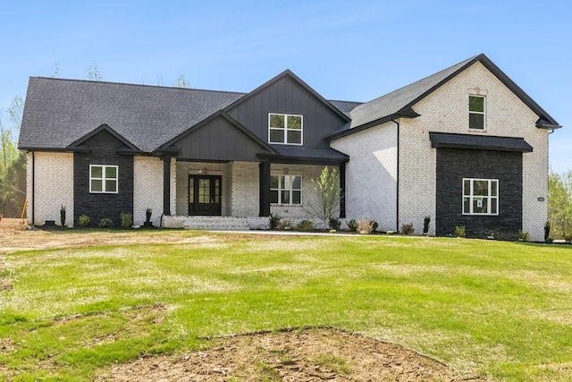 1049 Gholson Rd, Clarksville, TN 37043 - view of front facade featuring brick siding, roof with shingles, a front lawn, and covered porch