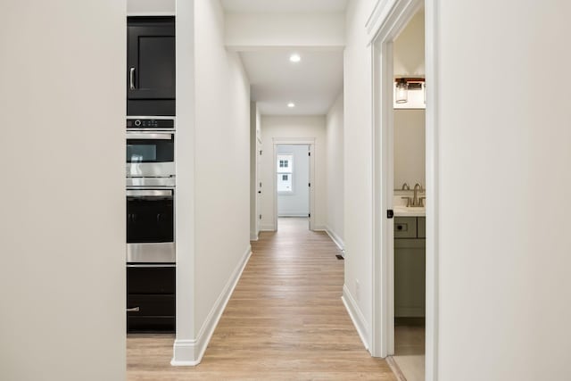 1049 Gholson Rd, Clarksville, TN 37043 - hallway with recessed lighting, light wood-style flooring, baseboards, and a sink