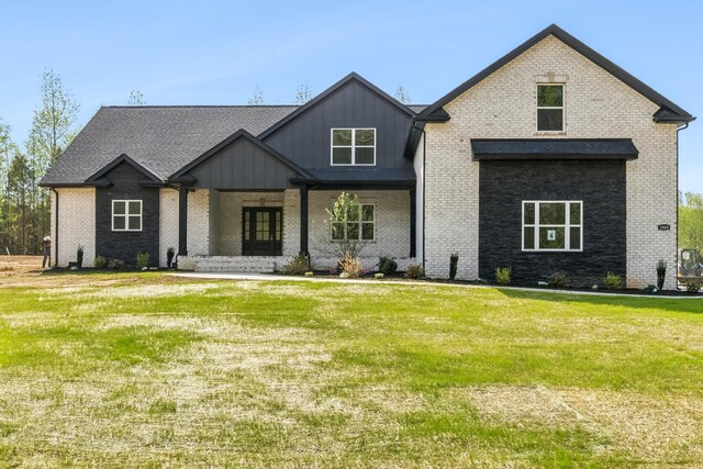 1049 Gholson Rd, Clarksville, TN 37043 - view of front of home with board and batten siding, a front lawn, covered porch, and brick siding