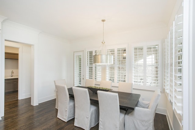 dining space with baseboards, dark wood finished floors, and crown molding