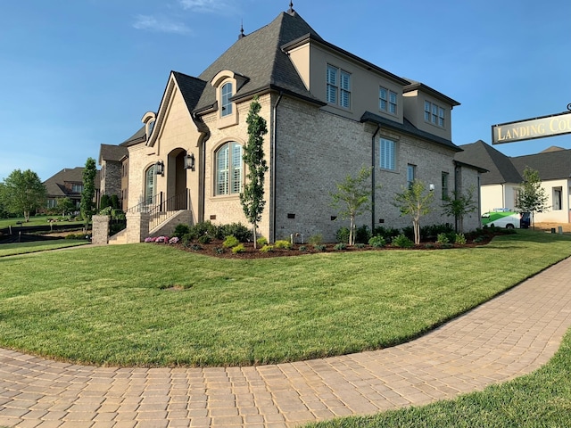 view of home's exterior with crawl space, brick siding, and a lawn