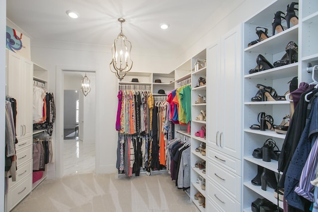 spacious closet with light colored carpet and a notable chandelier