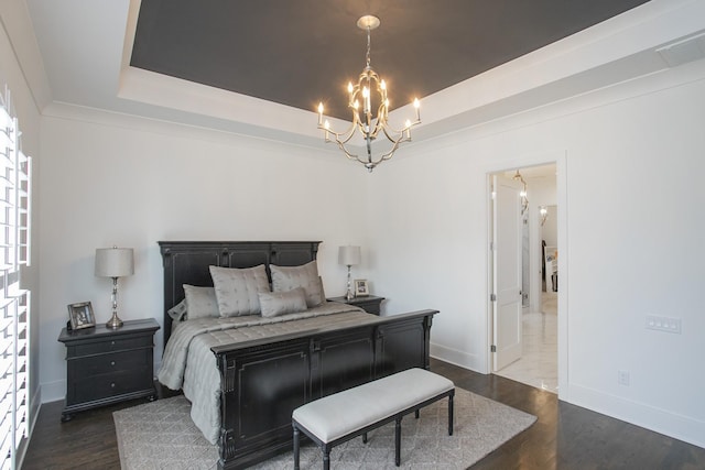 bedroom featuring a tray ceiling, dark wood finished floors, visible vents, and a notable chandelier