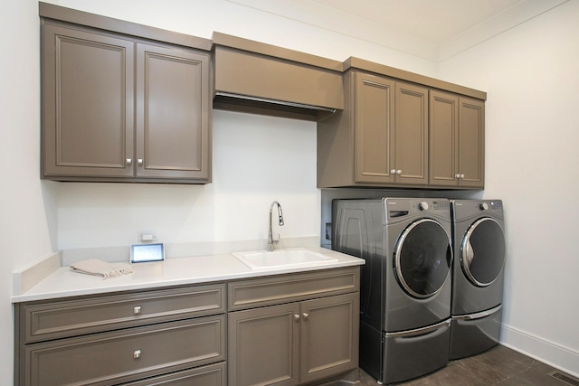 laundry room with washer and dryer, cabinet space, a sink, and visible vents