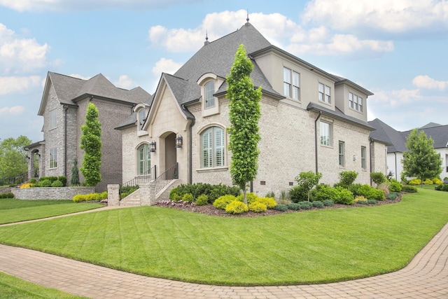 1141 Landing Pvt Ct, Gallatin, TN 37066 - french country style house featuring a front yard, brick siding, and a shingled roof
