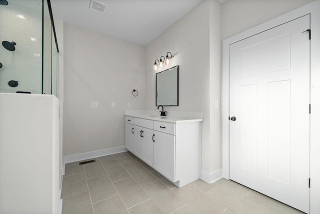 bathroom featuring tile patterned floors, a shower, and vanity