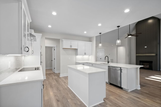 kitchen with a center island, dishwasher, sink, kitchen peninsula, and white cabinets