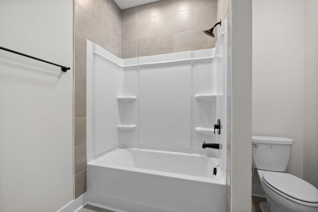 bathroom featuring tiled shower / bath and toilet