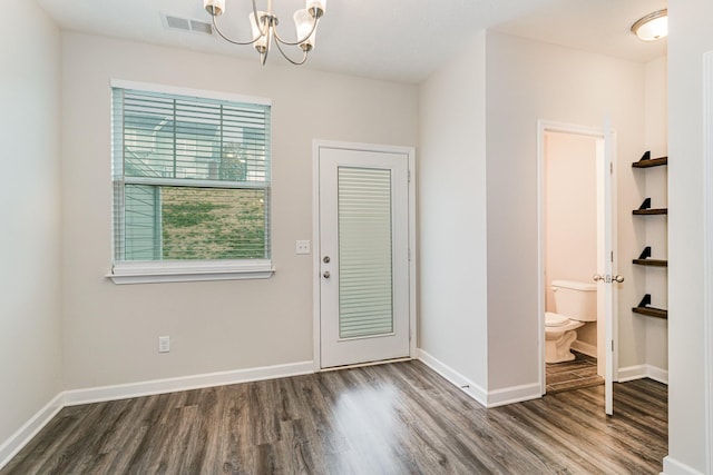 entrance foyer with dark hardwood / wood-style floors and an inviting chandelier