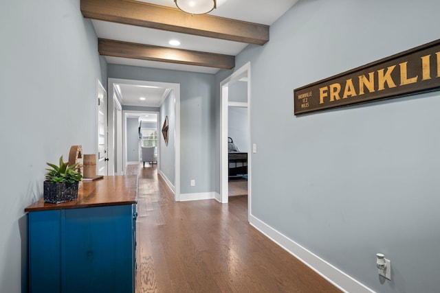 corridor featuring beamed ceiling and dark hardwood / wood-style flooring