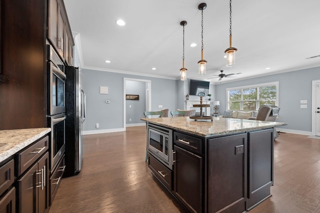 kitchen with dark wood-type flooring, decorative light fixtures, a kitchen island, dark brown cabinetry, and stainless steel appliances