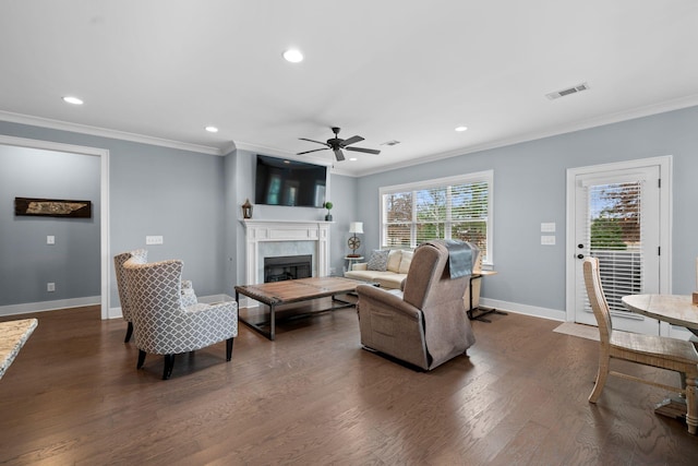 living room with dark hardwood / wood-style floors, ornamental molding, and a fireplace