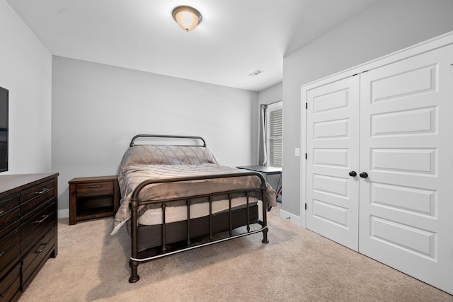 bedroom featuring light carpet and a closet