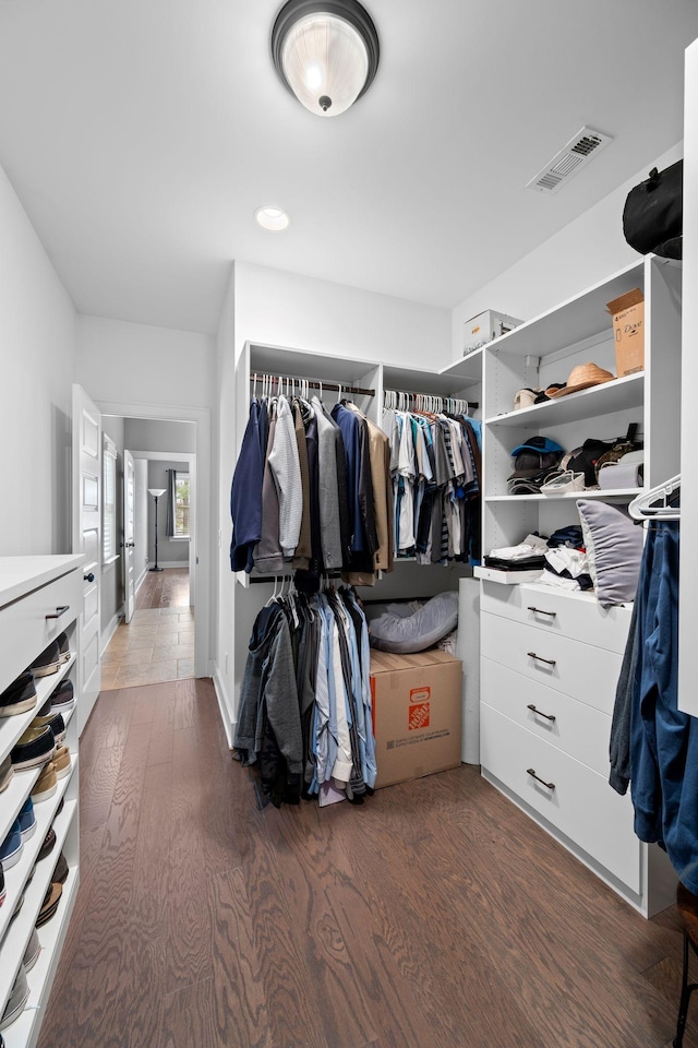 spacious closet with dark hardwood / wood-style flooring