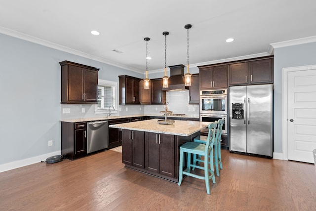 kitchen featuring pendant lighting, dark hardwood / wood-style floors, a center island, and stainless steel appliances