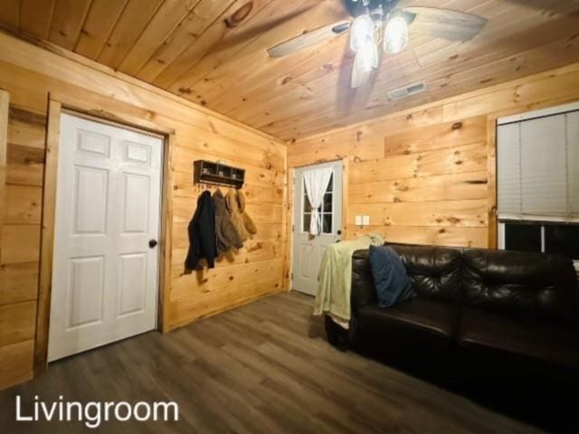 interior space with wood walls, dark hardwood / wood-style floors, ceiling fan, and wood ceiling