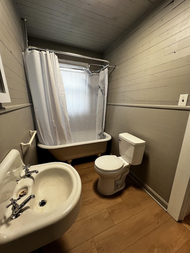 full bathroom with shower / bath combination with curtain, sink, wood-type flooring, and toilet