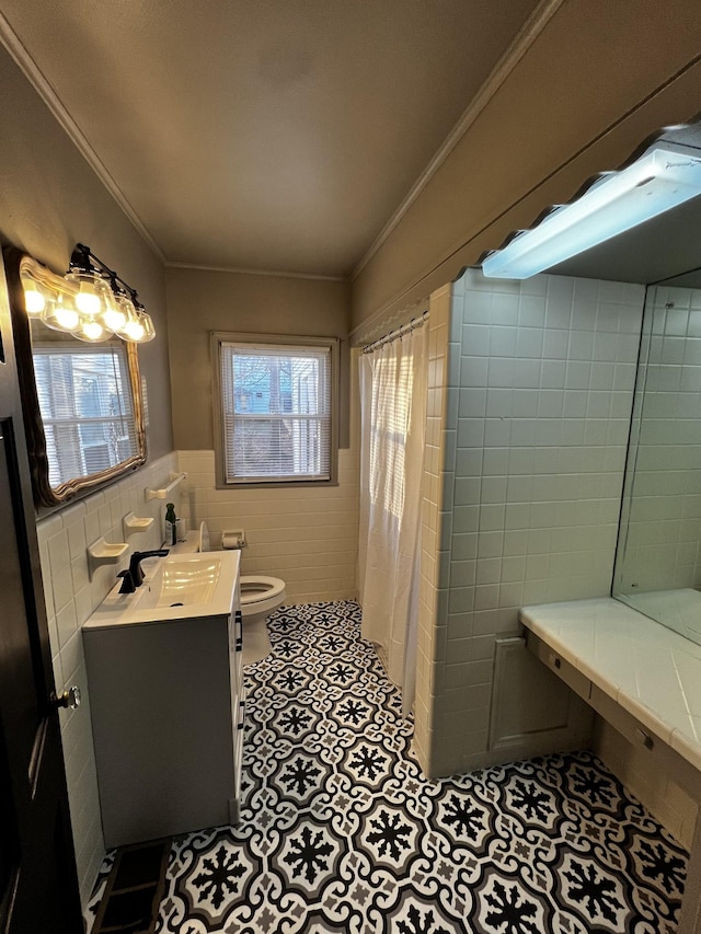 bathroom with a shower with shower curtain, ornamental molding, vanity, tile walls, and toilet