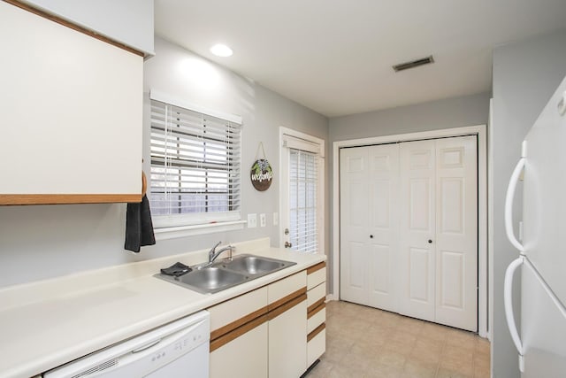 kitchen with white cabinets, white appliances, and sink