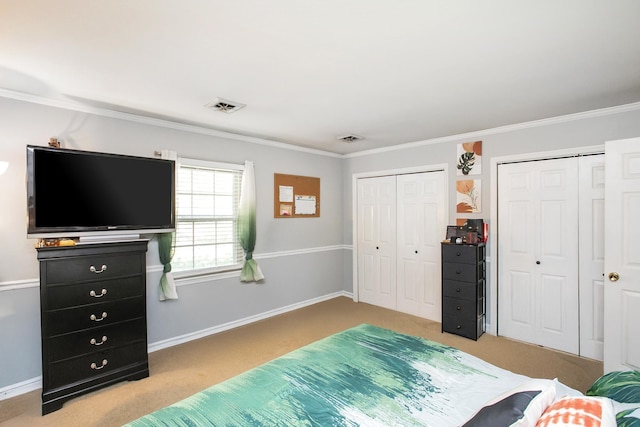 bedroom featuring light colored carpet, crown molding, and multiple closets