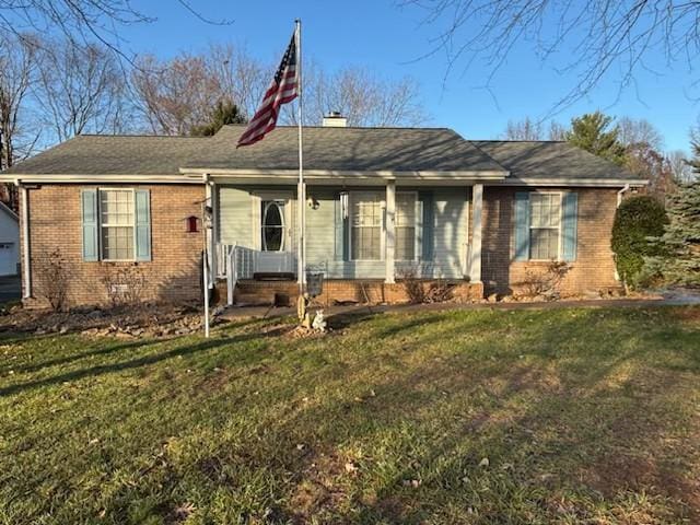 single story home with a front lawn, an outdoor structure, and a garage