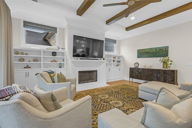 living room featuring beamed ceiling, wood-type flooring, and ceiling fan