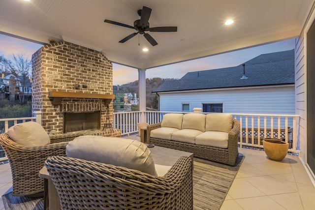 deck at dusk with ceiling fan and an outdoor brick fireplace