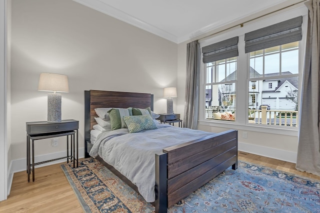 bedroom featuring light hardwood / wood-style flooring and ornamental molding