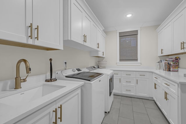 laundry room with cabinets, washing machine and dryer, light tile patterned flooring, and sink