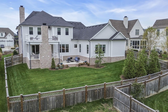 rear view of house featuring a lawn, a patio area, and a balcony