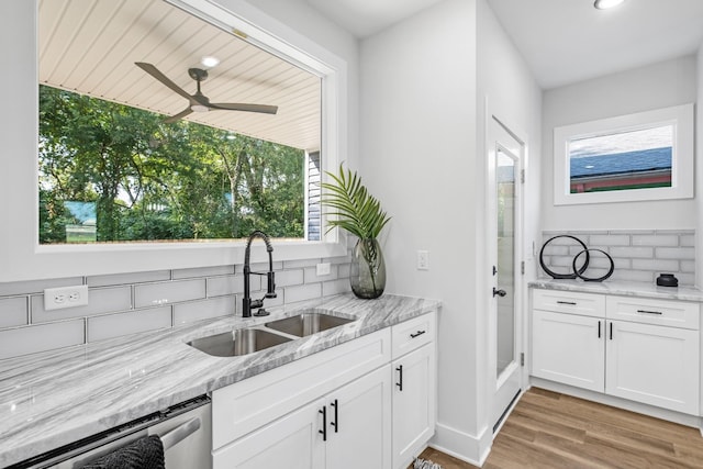 kitchen with backsplash, white cabinetry, sink, and light wood-type flooring