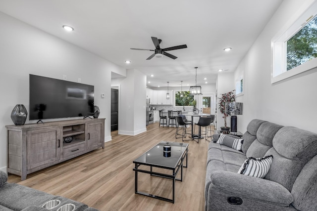 living room featuring light hardwood / wood-style flooring, a wealth of natural light, and ceiling fan