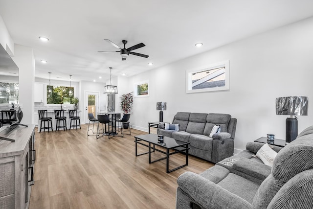 living room featuring light hardwood / wood-style flooring and ceiling fan