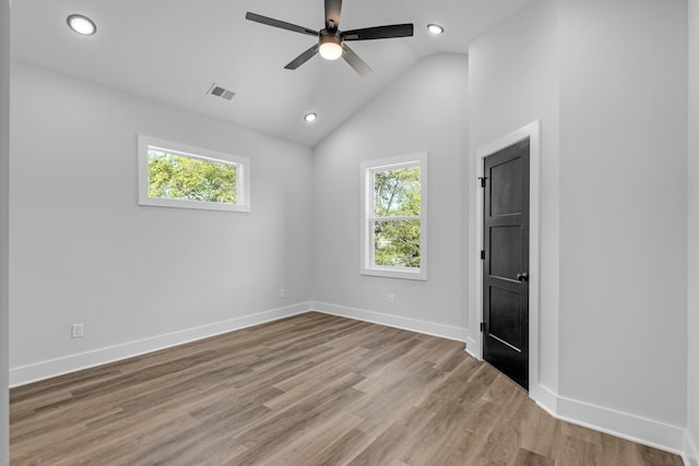 empty room with ceiling fan, light hardwood / wood-style flooring, and high vaulted ceiling