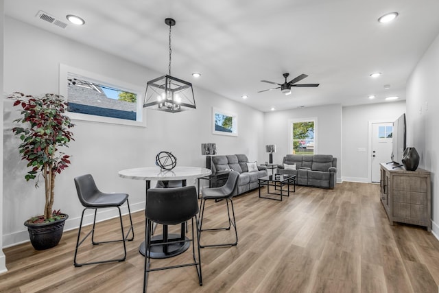 dining room featuring wood-type flooring and ceiling fan with notable chandelier