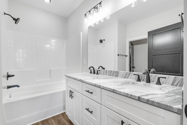 bathroom with hardwood / wood-style floors, vanity, and shower / tub combination