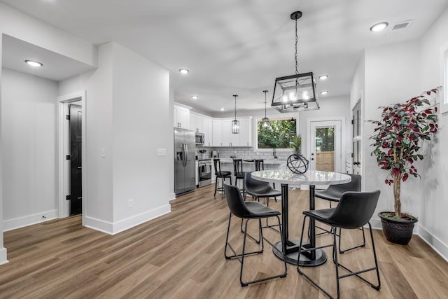 dining room with sink and light hardwood / wood-style floors