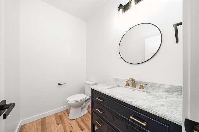 bathroom featuring wood-type flooring, vanity, and toilet