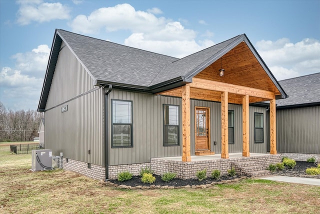 view of front of property featuring a porch, central AC unit, and a front lawn