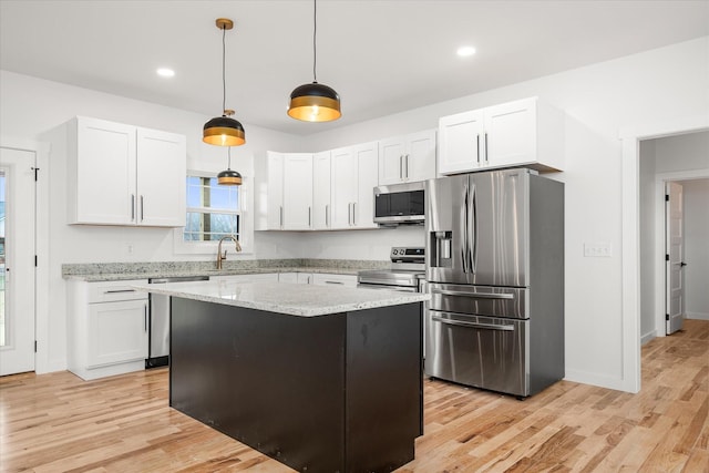 kitchen with white cabinetry, decorative light fixtures, and stainless steel appliances