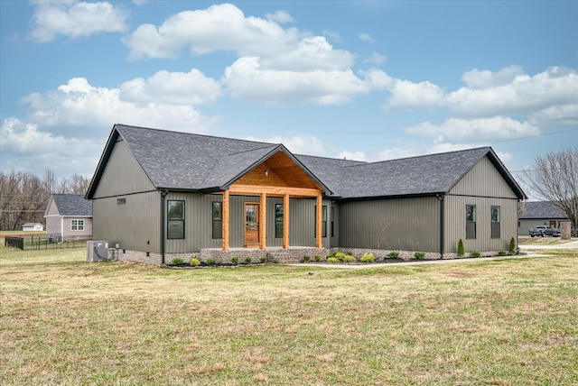 modern farmhouse style home featuring central AC unit, a front yard, and covered porch