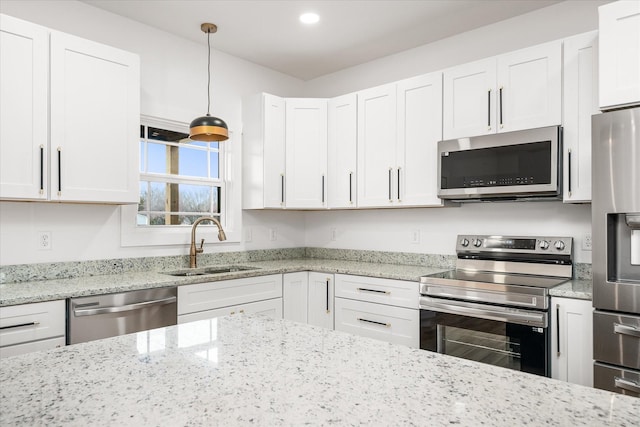 kitchen with stainless steel appliances, white cabinetry, hanging light fixtures, and sink