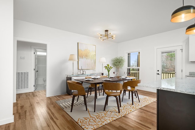 dining space featuring a chandelier and light wood-type flooring