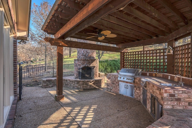 view of patio with an outdoor brick fireplace, an outdoor kitchen, sink, ceiling fan, and area for grilling