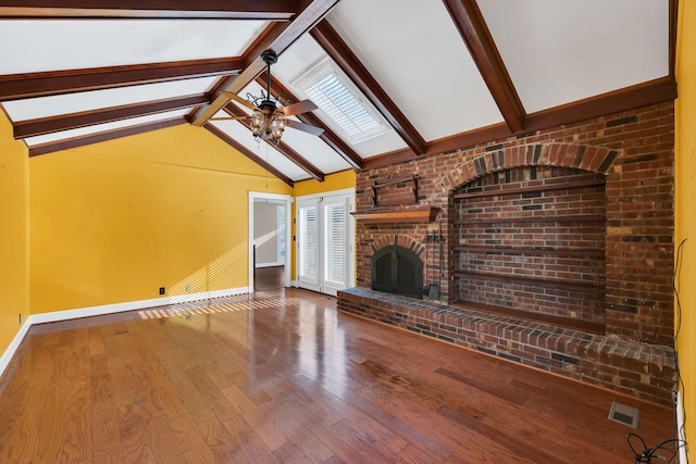 unfurnished living room with vaulted ceiling with skylight, ceiling fan, a fireplace, a wealth of natural light, and wood-type flooring