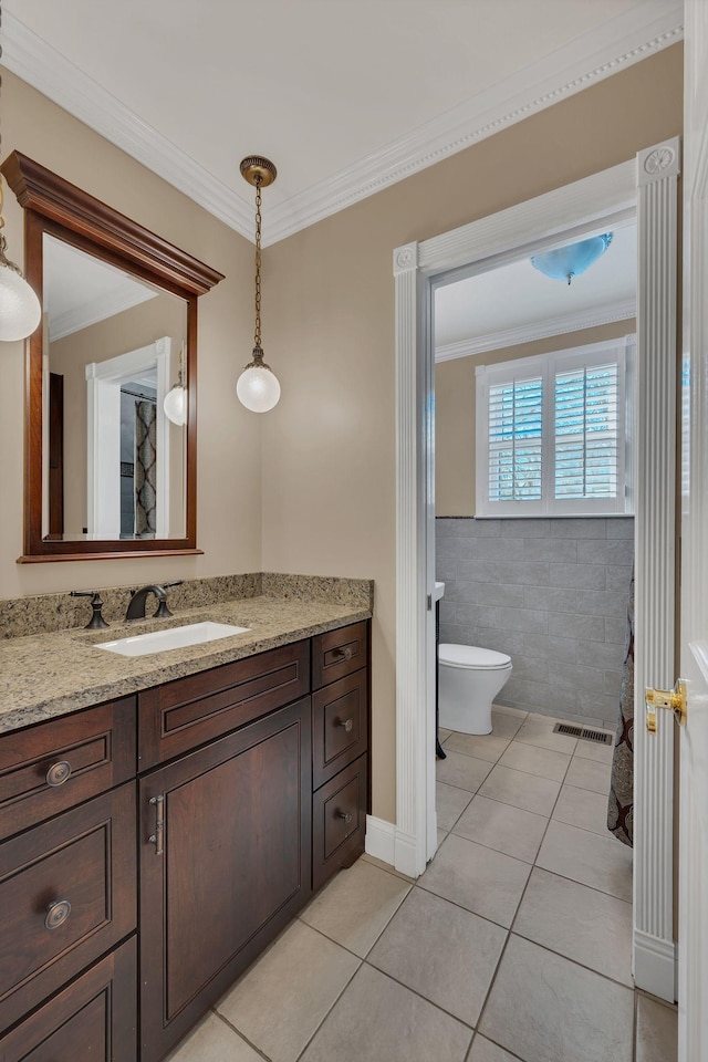 bathroom featuring vanity, crown molding, tile patterned flooring, toilet, and tile walls