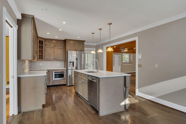 kitchen featuring stainless steel appliances, a kitchen island with sink, dark wood-type flooring, sink, and pendant lighting