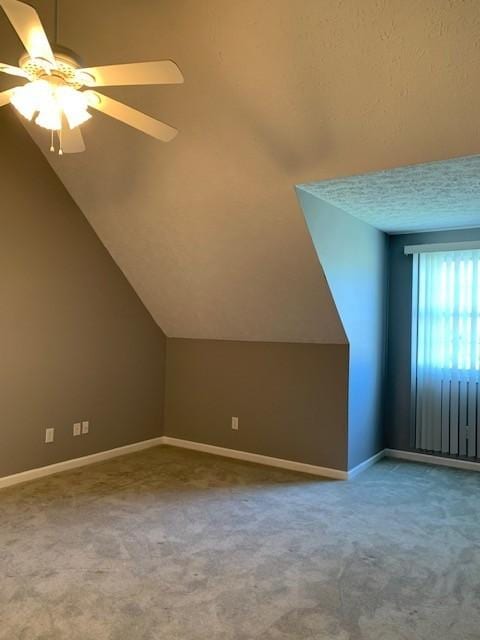 bonus room with carpet flooring, ceiling fan, a textured ceiling, and vaulted ceiling
