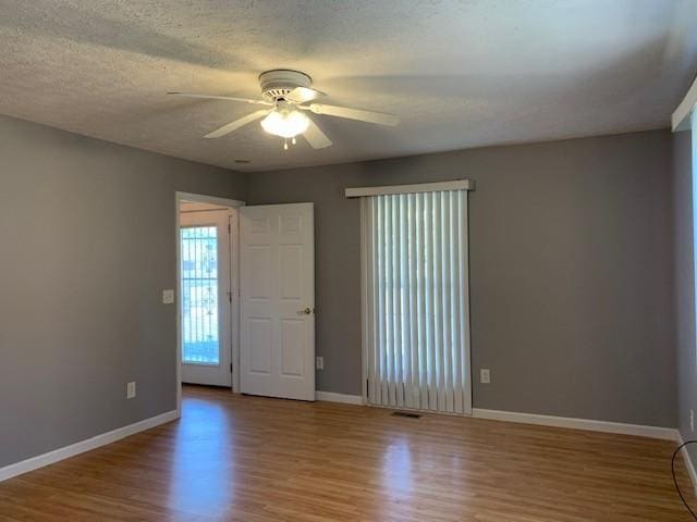 unfurnished room with ceiling fan, light hardwood / wood-style floors, and a textured ceiling